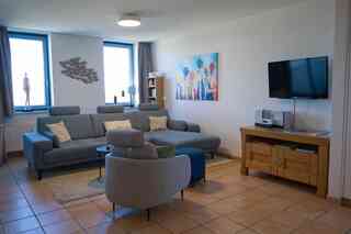 Inselblume 50 - Ferienwohnung von privat in der Strandburg – Wohnzimmer mit Couch und Sessel in der Ferienwohnung in der Strandburg auf Fehmarn